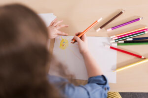 Child learning handwriting techniques by drawing