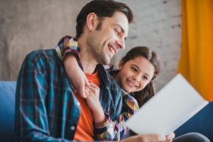 Father and daughter reading positive affirmations on paper together