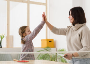 Child and therapist high fiving each other