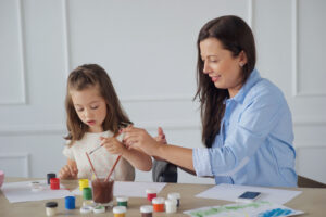 pediatric occupational therapist painting with child