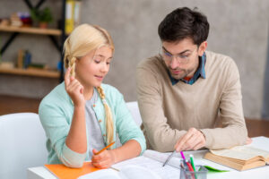 student learning to write with occupational therapist